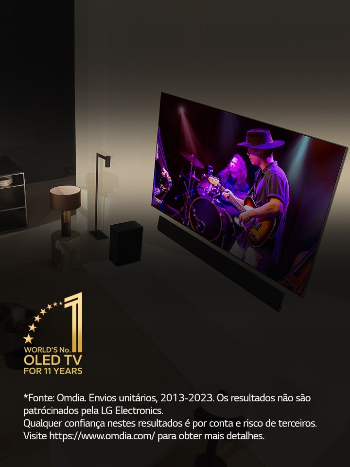 Uma perspetiva aérea de um homem e uma mulher a assistir a um concerto numa grande OLED TV num apartamento moderno. Aparece na imagem o emblema "A OLED TV número 1 do mundo há 11 anos". Uma declara??o de isen??o de responsabilidade diz o seguinte: “Fonte: Omdia. Envios unitários, 2013 a 2023. Os resultados n?o s?o patrocinados pela LG Electronics. Qualquer confian?a nestes resultados é por conta e risco de terceiros. Visite https://www.omdia.com/ para obter mais detalhes.”