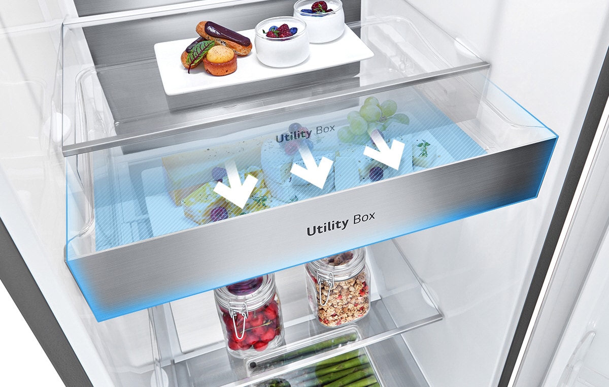 O interior do frigorífico mostra uma gaveta chamada de "Utility Box". Três setas indicam que a gaveta pode ser aberta para aceder aos alimentos que est?o no interior.