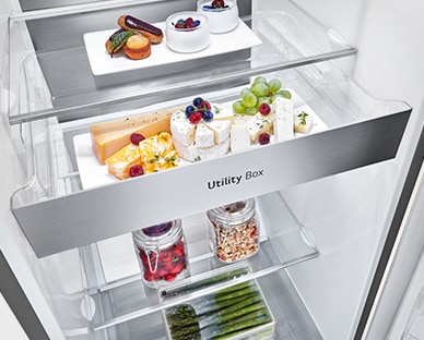 O interior do frigorífico mostra uma gaveta chamada de ''Utility Box''. Três setas indicam que a gaveta pode ser aberta para aceder aos alimentos que est?o no interior.