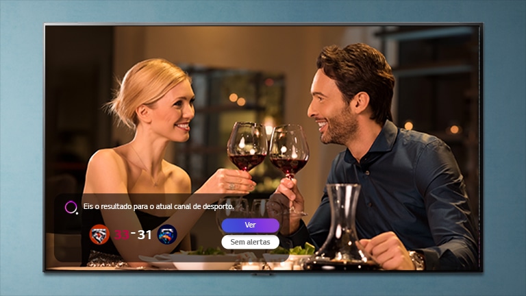 Um homem e uma mulher a brindar num ecr? de TV enquanto soam as notifica??es dos alertas de desporto