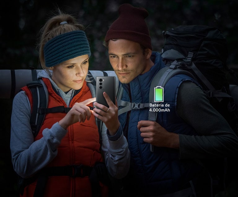 Casal a ver o ecr? de um smartphone enquanto escala à noite.