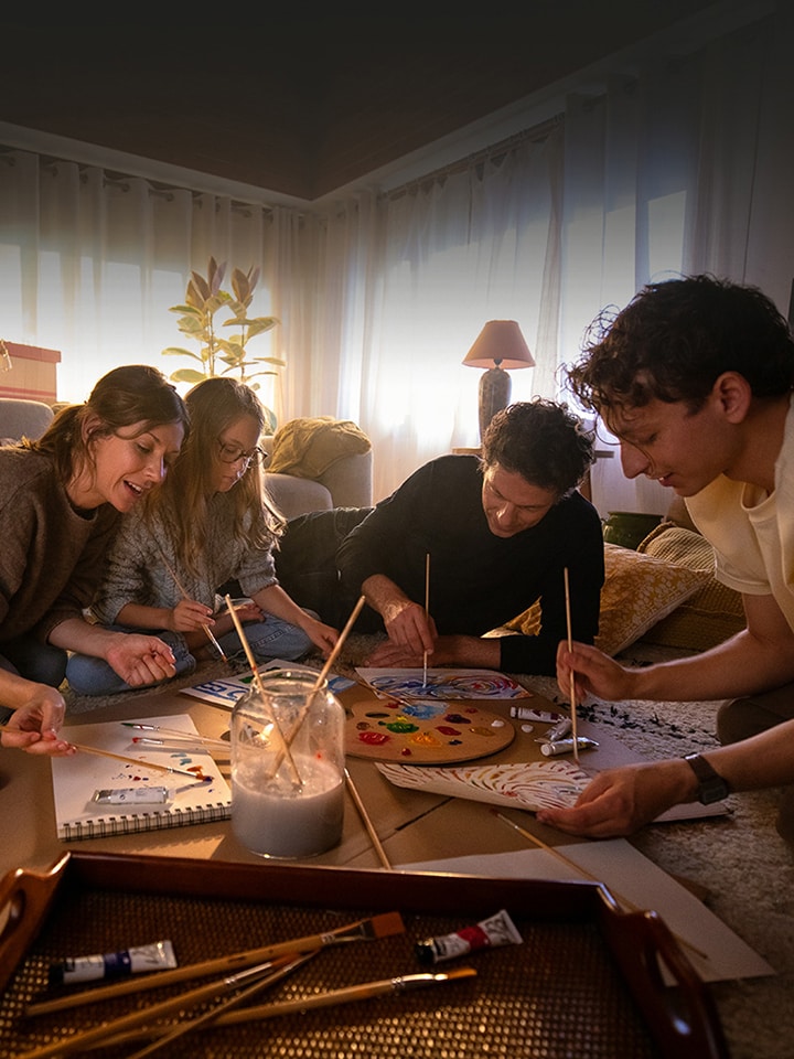 Familjen samlas p? den mysiga vardagsrumsmattan och ritar bilder i ett varmt hus.	