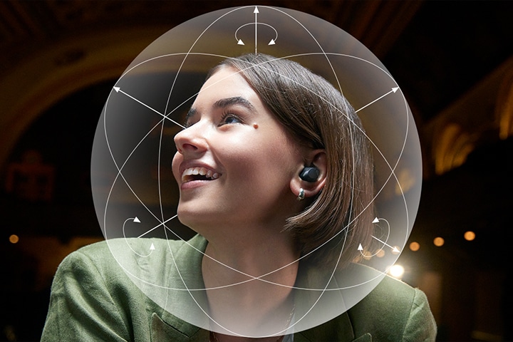 En kvinna som b?r T90S ler. En illustrativ sf?r visas runt hennes huvud f?r att framh?va Dolby Head tracking?-funktionen.