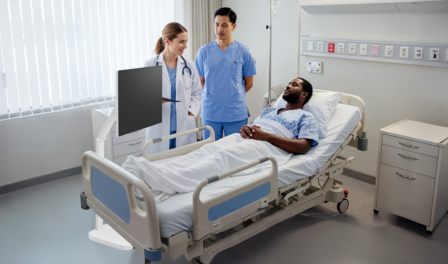 A patient is lying in a hospital bed, with two medical professionals standing beside them. A LG Smart Monitor Swing is next to the doctor.