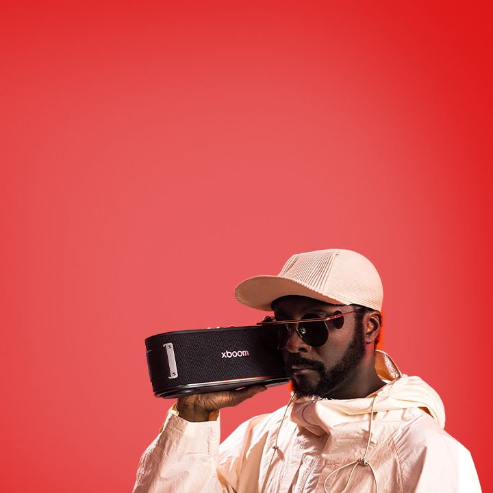 will.i.am beyaz k?yafet ve güne? g?zlü?üyle, xboom Bounce’u yüzünün hemen yan?nda tutuyor.