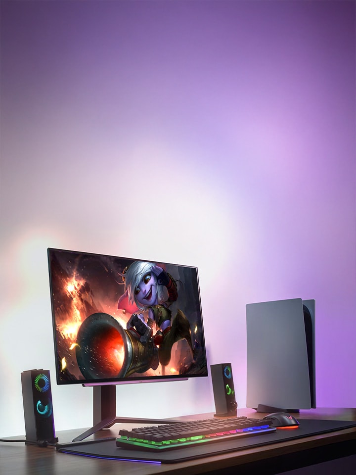 27GS95QE-B on a desk with a PS5, lit up by a purple glow in the background