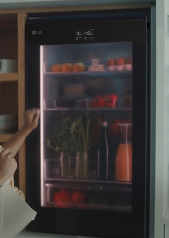 Image of a woman knocking on the top of a refrigerator.