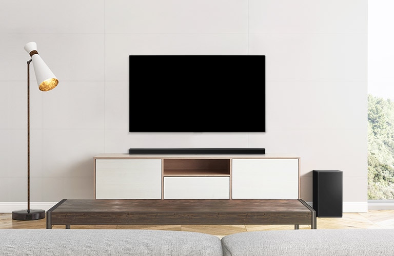 A TV and a soundbar placed in a plain living room.