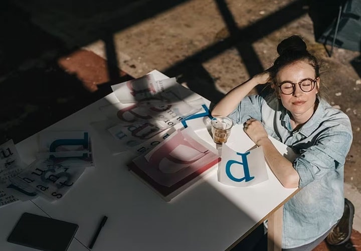A woman looks away from her screen to rest her eyes