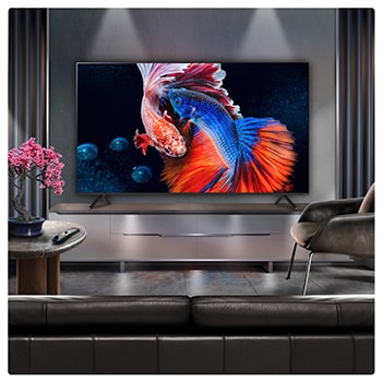 A family sits on a couch facing a LG QNED TV sitting above a TV stand with a little girl pointing to a screen depicting two dolphins. The title talks about how you can enjoy high resolution on a massive screen.