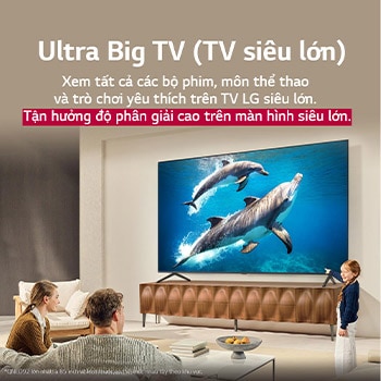 C? gia ?ình ng?i trên chi?c gh? dài ??i di?n LG QNED TV n?m phía trên k? TV, m?t c? bé ch? vào màn hình ?ang chi?u c?nh hai chú cá heo. Tiêu ?? nói v? cách b?n tr?i nghi?m ?? phan gi?i cao trên màn hình l?n.