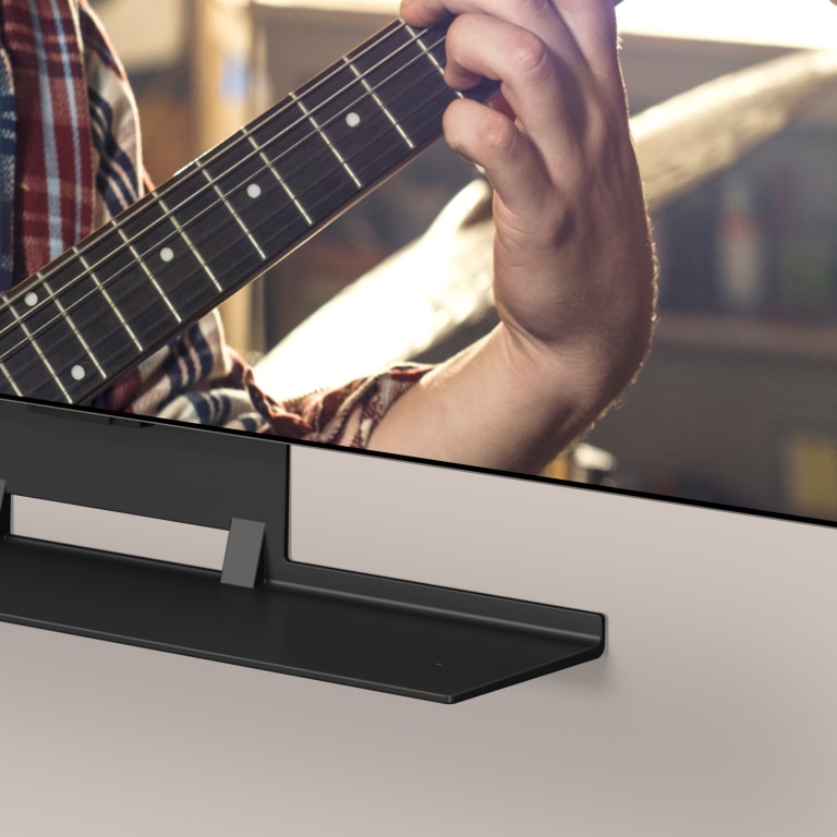 An image shows a modern living house. TV and Soundbar are matched together with the synergy bracket.