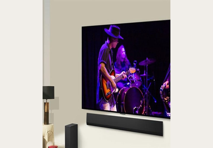 TV OLED com soundbar da LG exibindo uma apresenta??o de música ao vivo. Perfeita para jogos com qualidade de som e imagem superior.