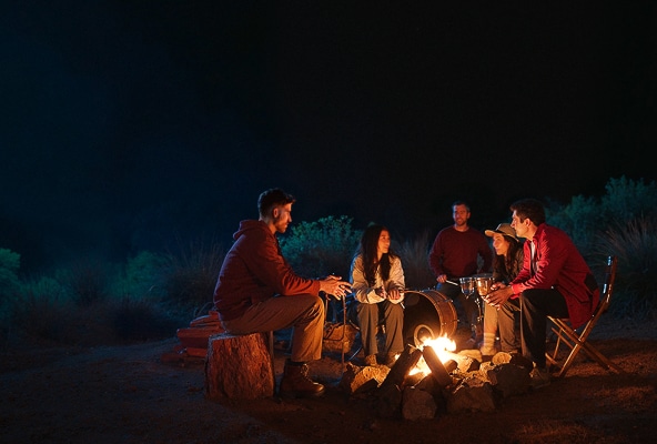 Des personnes souriantes qui s’amusent au camping, grace au pouvoir de l’optimisme.