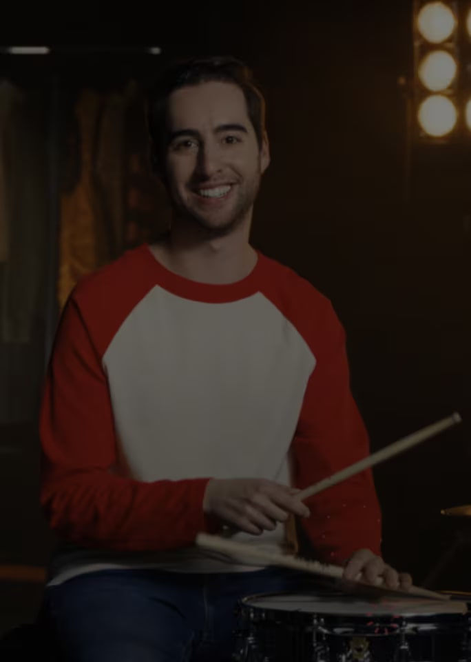 Josh Harmon egy dobkészlet el?tt, világítás mellett.