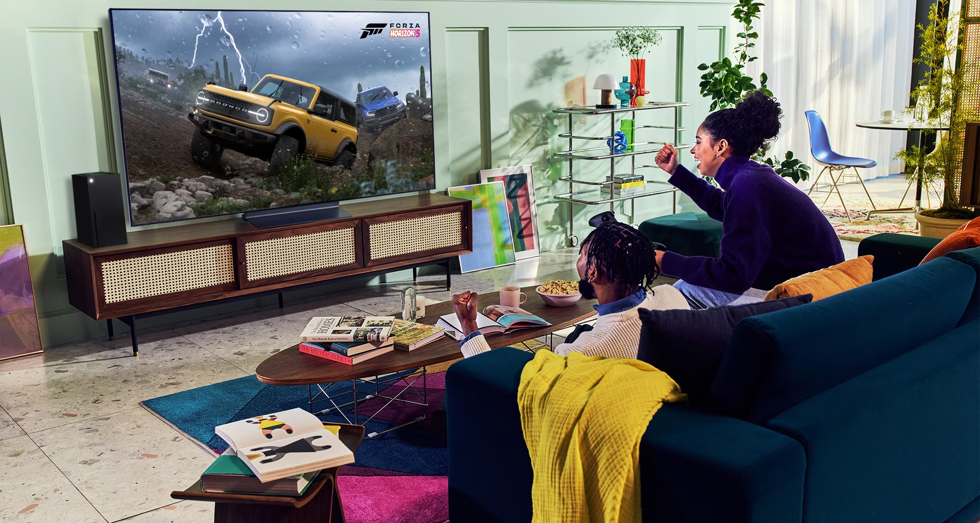 A person plays a racing game with an XBOX Series X|S controller on an LG OLED television