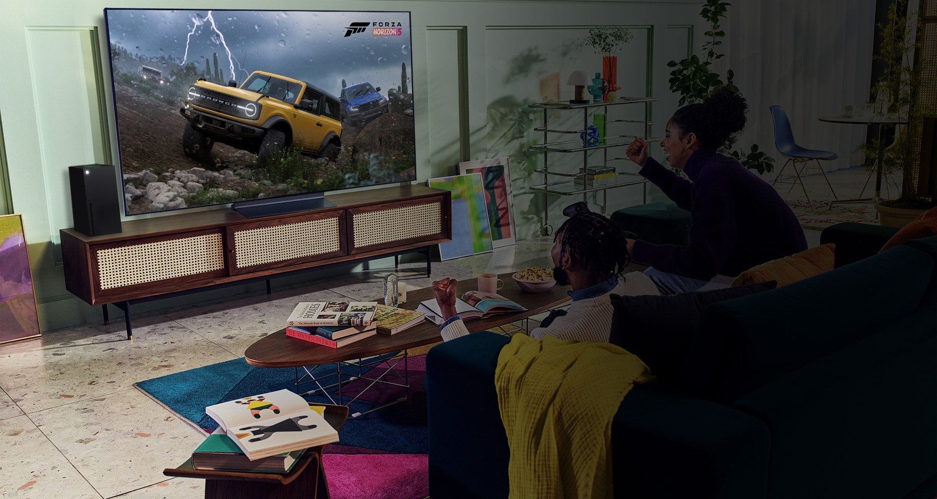 A person plays a racing game with an XBOX Series X|S controller on an LG OLED television