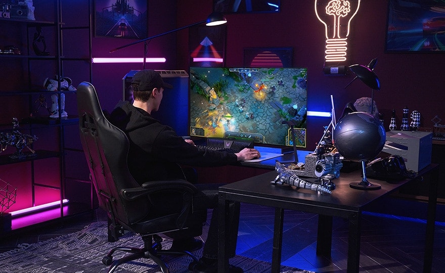 Um homem a jogar na televis?o OLED mais pequena da LG enquanto está sentado numa secretária