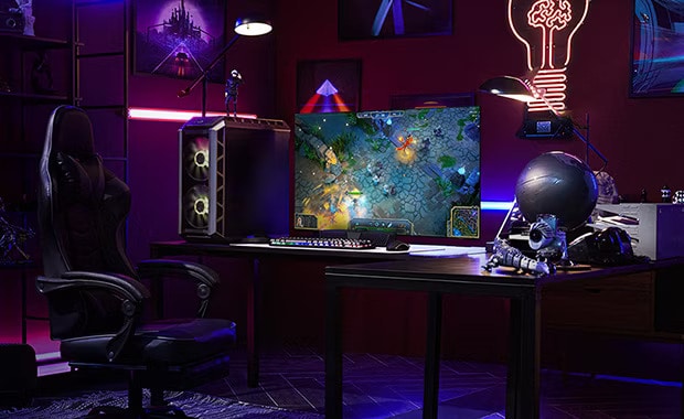 Un hombre sentado en un escritorio juega en el televisor LG OLED más peque?o