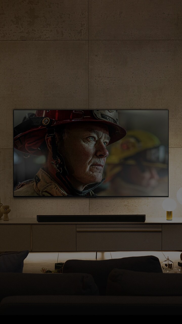 Un LG OLED TV de pared está en una habitación blanca y brillante con decoración en tonos naturales. A medida que la pantalla se mueve, la escena cambia del día a la noche. with Logo Dolby Vision IQ