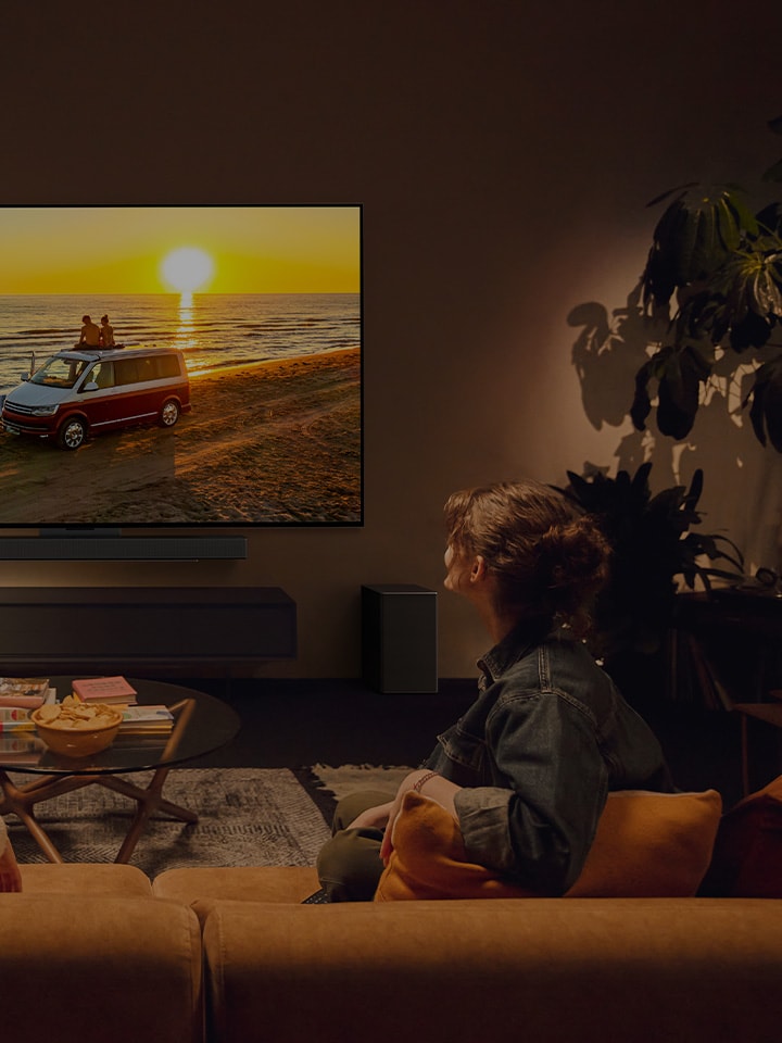 Tv? personer i ett st?mningsfullt vardagsrum med en LG-TV p? v?ggen. 