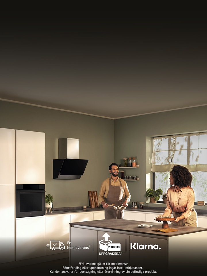 "Modernt k?k med tv? kvinnor som ler och samtalar vid en k?ks?. K?ket har stilrena vitvaror, mjuk belysning och ett stort f?nster som sl?pper in naturligt ljus. Logotyper f?r varum?rkena Candy och Haier syns till v?nster.