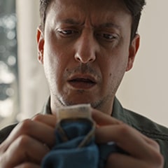A man reading the tag on a pair of pants.