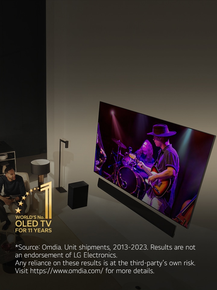 An overhead perspective of a man and woman watching a concert on a large OLED TV in a modern apartment. The "World's number 1 OLED TV for 11 Years" emblem is in the image.?