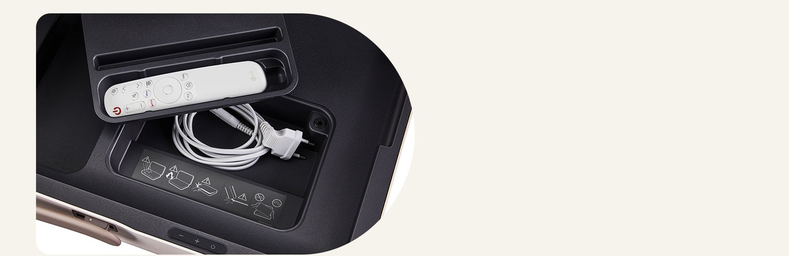 Primer plano del LG StanbyME Go, que muestra los compartimentos integrados. Un control remoto LG se coloca dentro del compartimiento más peque?o y el cable de alimentación se encuentra debajo.