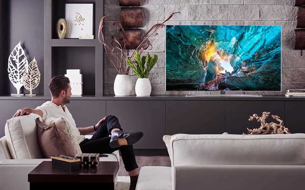 A man and lg signature wallpaper tv w7 in a living room.
