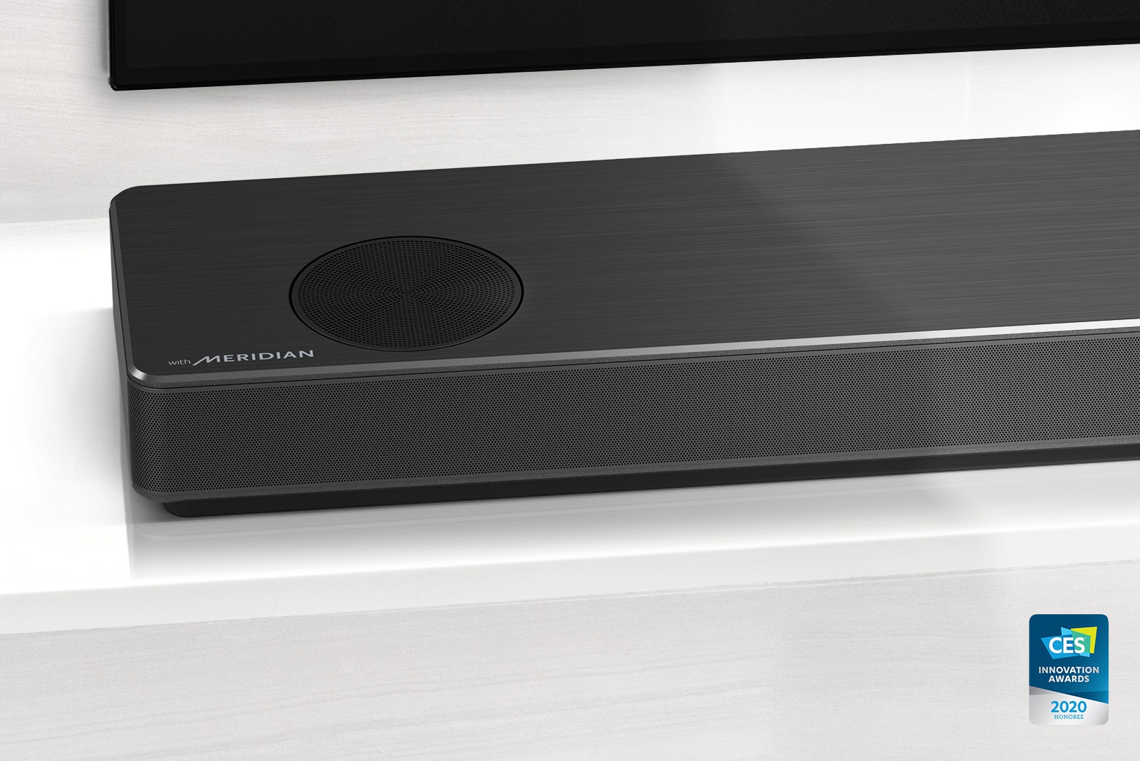 L?hikuva LG-soundbar-kaiuttimen vasemmasta reunasta, jonka vasemmassa alakulmassa n?kyy Meridian-logo. Television vasen alareuna on my?s n?kyviss?. 