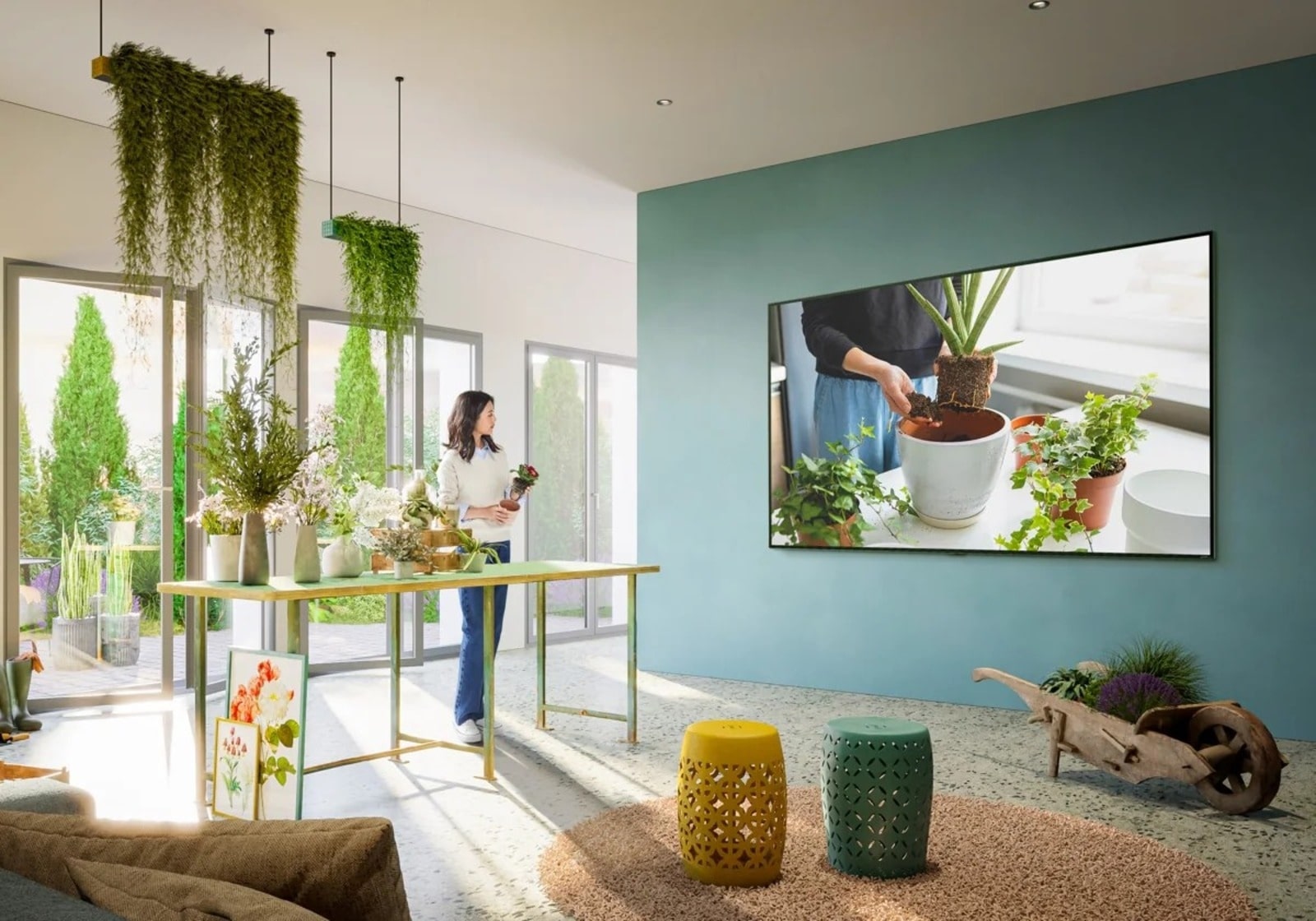 un espace de vie lumineux, orné de plantes, avec un téléviseur mural LG affichant l’écran d’accueil webOS. La pièce allie nature et technologie, créant une atmosphère sereine.