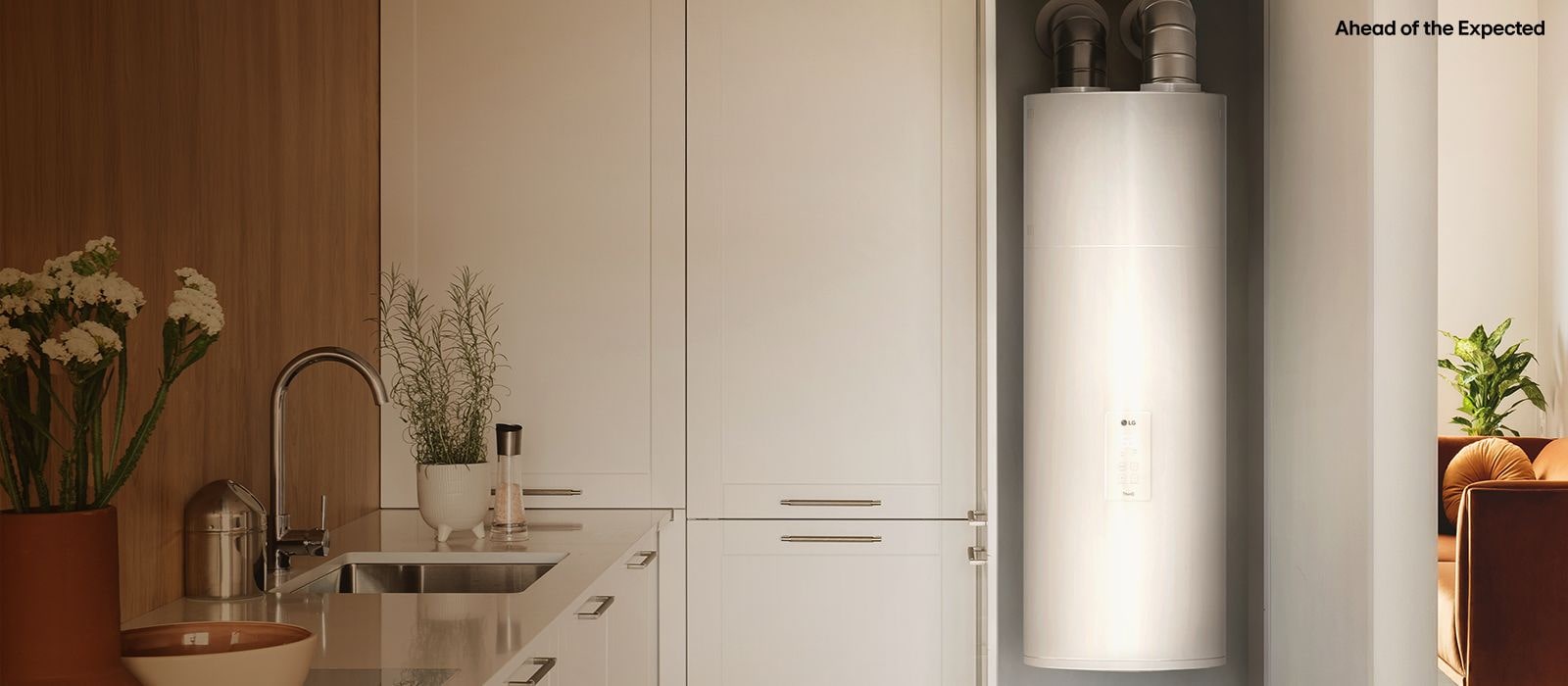 Modern kitchen with white cabinetry and LG water heater, featuring 'Ahead of the Expected' branding.