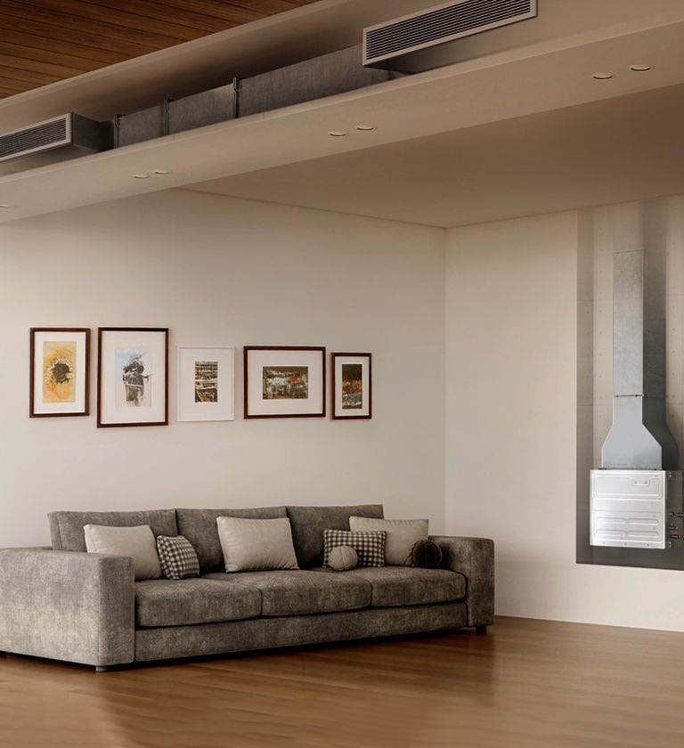 Modern living room with grey sectional sofa, wall art, visible HVAC duct, wood accents, and window view of greenery.
