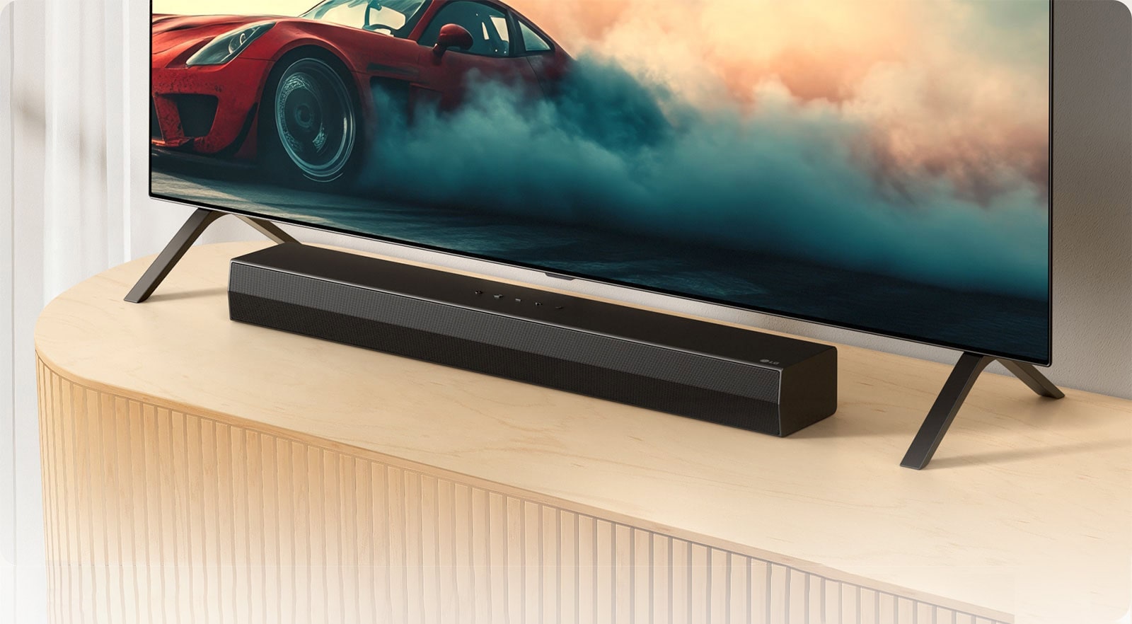 Το LG Soundbar S20A τοποθετε?ται σε μια ξ?λινη κονσ?λα τηλε?ραση?, κ?τω απ? μια τηλε?ραση και αν?μεσα στι? β?σει? τη? τηλε?ραση?. Στην τηλε?ραση εμφαν?ζεται ?να κ?κκινο αυτοκ?νητο με καπν?.