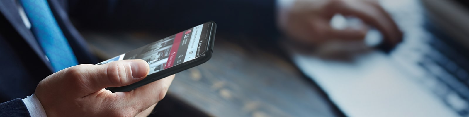 Μια εικ?να εν?? ?νδρα που κρατ? ?να smartphone με την ιστοσελ?δα τη? LG στην οθ?νη.