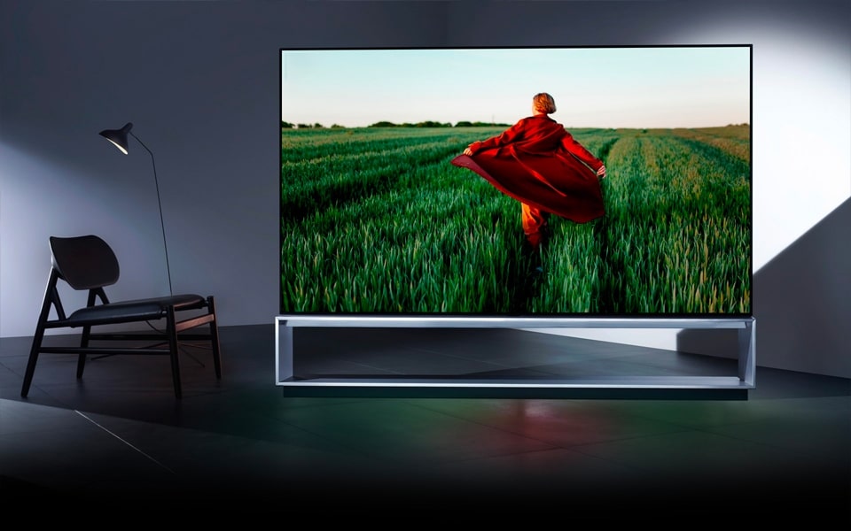 Η LG ΥΠΟΓΡΑΦΗ OLED τηλε?ραση δε?χνει ?να πρ?σωπο που τρ?χει μ?σα απ? ?να πεδ?ο.
