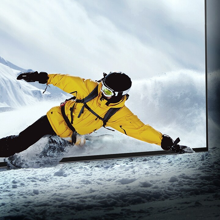 ?να? snowboarder γ?ρνει μ?σα απ? την οθ?νη τη? τηλε?ραση? LG OLED εν? το χι?νι ζωντανε?ει μ?σα στο δωμ?τιο.