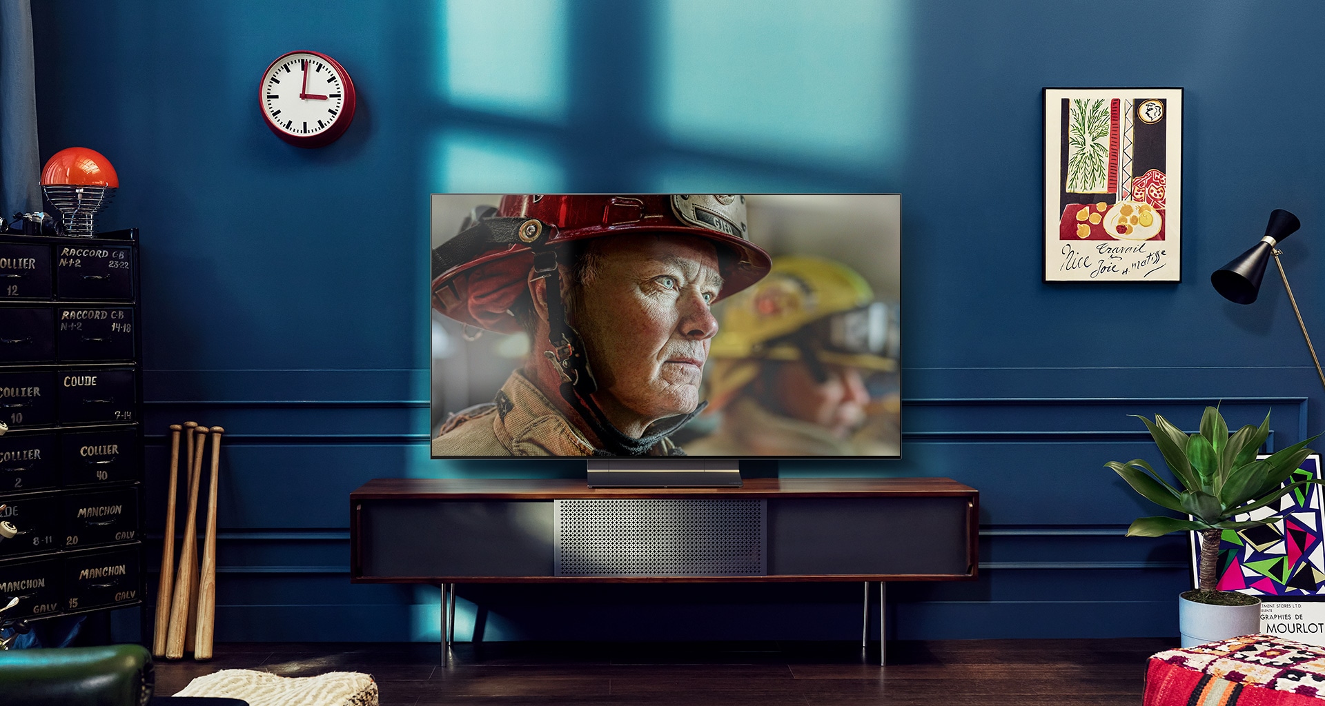 Μια επιτο?χια τηλε?ραση LG OLED βρ?σκεται σε ?να λευκ? και φωτειν? δωμ?τιο με φυσικ? διακ?σμηση. Καθ?? κινε?ται η οθ?νη, η σκην? αλλ?ζει απ? ημ?ρα σε ν?χτα.