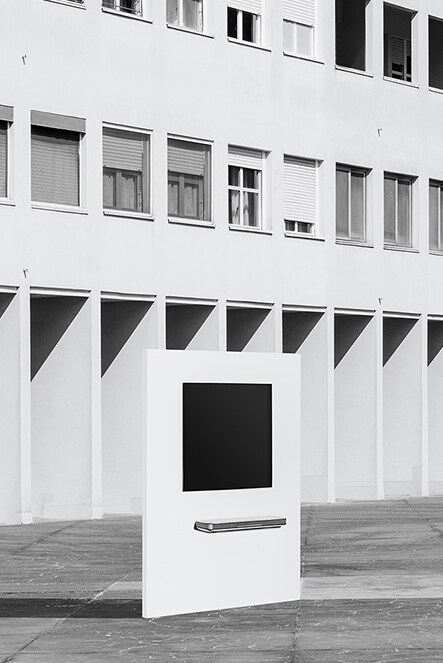 LG SIGNATURE oled tv w sospeso a parete davanti a un edificio con innumerevoli finestre