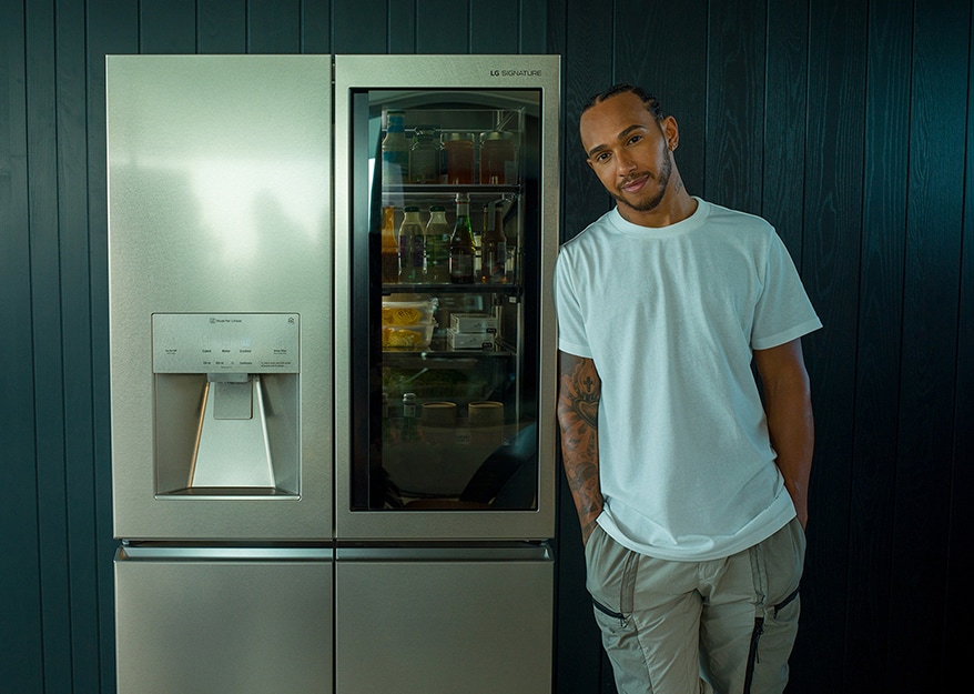 Lewis Hamilton appoggiato al Frigorifero LG SIGNATURE.