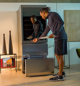 Lewis Hamilton che preme il display touch in vetro della Cantina LG SIGNATURE.