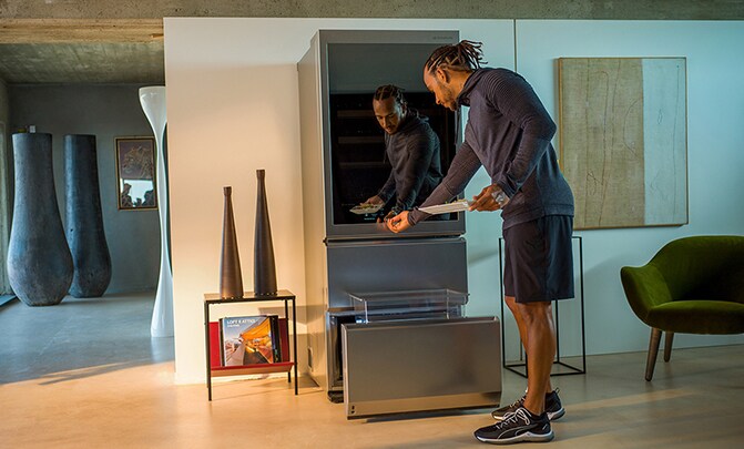 Lewis Hamilton che preme il display touch in vetro della Cantina LG SIGNATURE.