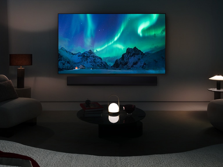 LG OLED TV ir LG garso juosta modernioje gyvenamojoje patalpoje nakties metu. Poliarin?s pa?vaist?s vaizdas ekrane rodomas idealiu ry?kumo lygiu.