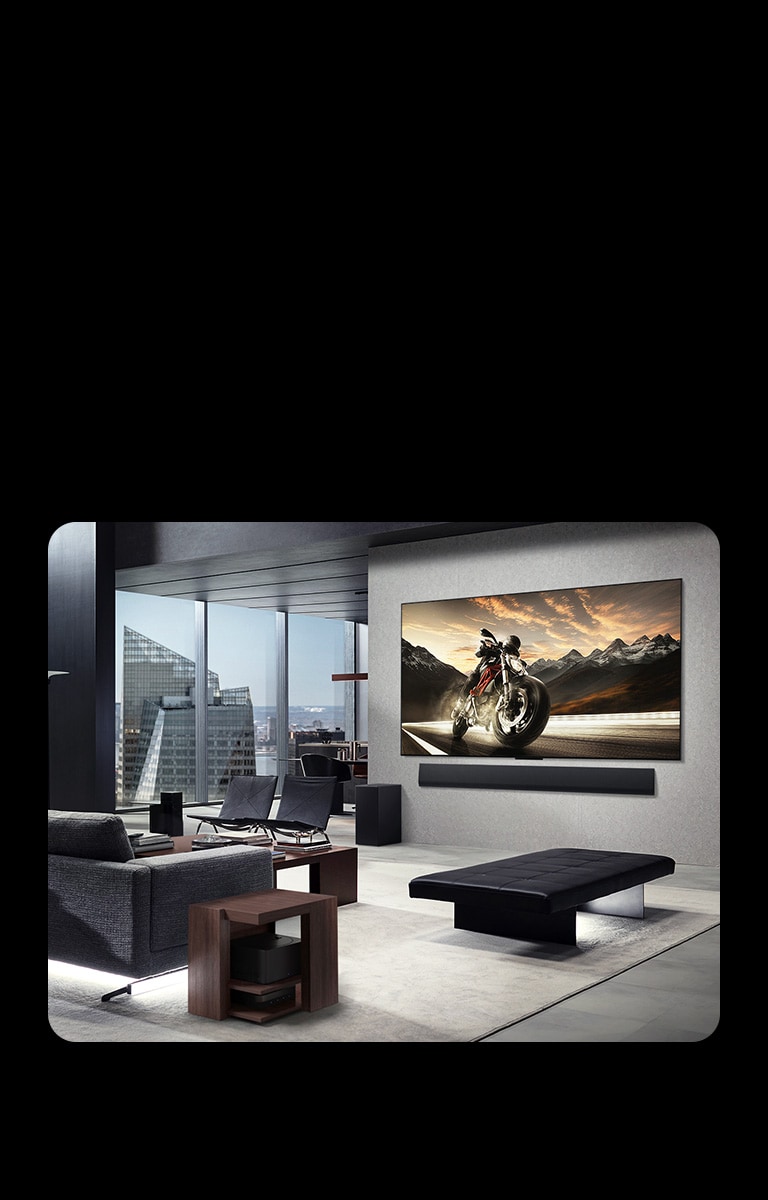 Pie sienas piestiprināts LG OLED M5 TV un LG Soundbar eleganta dzīvok?a dzīvojamajā istabā. Zero Connect Box paslēpts zem sānu galdi?a.