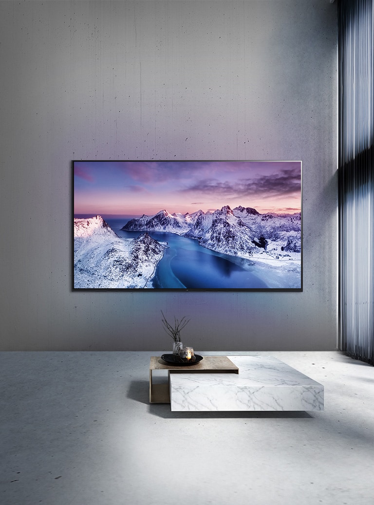 En UHD-TV montert p? veggen bak et bord i minimalistisk stil.