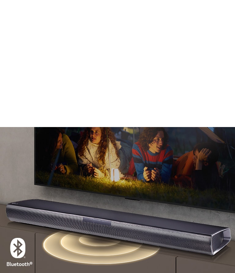 LG TV-en henger p? veggen. P? skjermen vises to par som ligger i gresset. Foran dem st?r det en lampe. LG-lydplanken st?r under LG TV-en. Det kommer lyd-grafikk ut fra fronten av lydplanken. Bluetooth-logoen vises nederst i h?yre hj?rne av bildet.