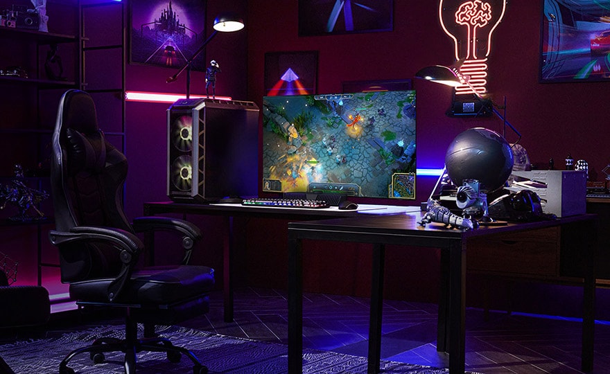 En mann spiller et spill p? den minste LG OLED-TV-en mens han sitter ved et skrivebord