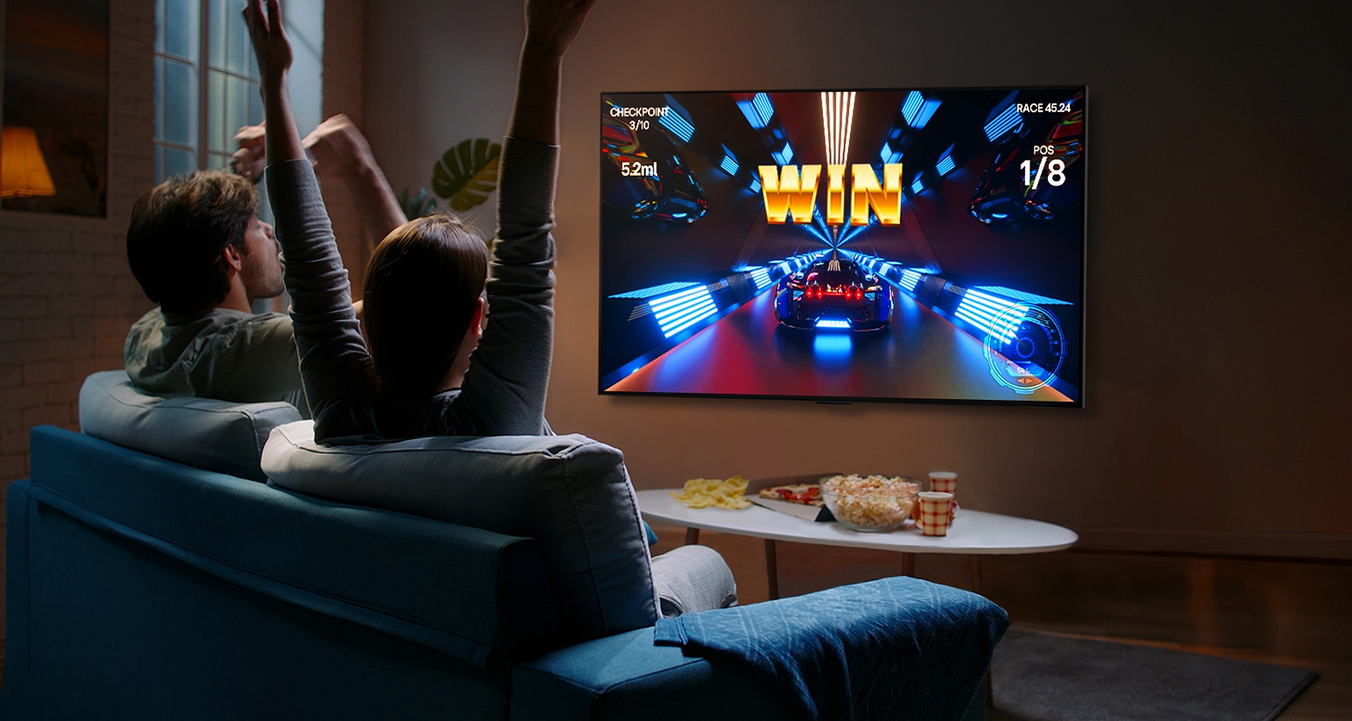 Mennesker spiller et spill med en kontroller p? LG OLED TV-en