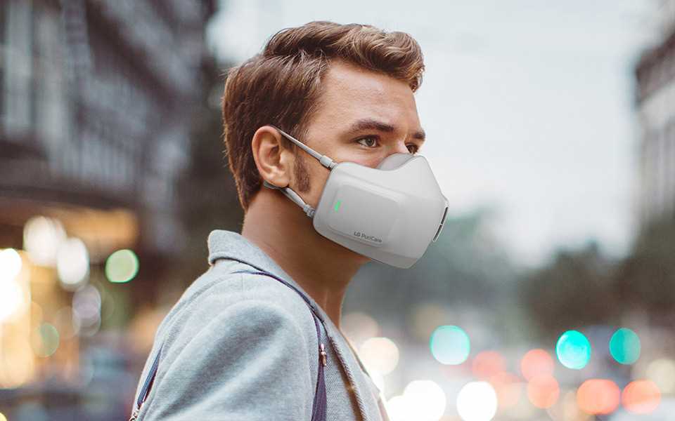 A man wearing the LG PuriCare? Wearable Air Purifier in public.